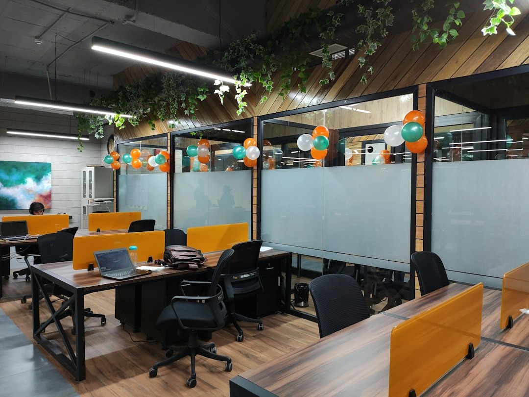 Office party with balloons and laptops on desks.